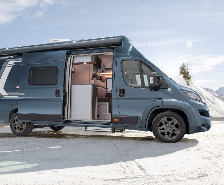 Campervan im Schnee mit offener Tür