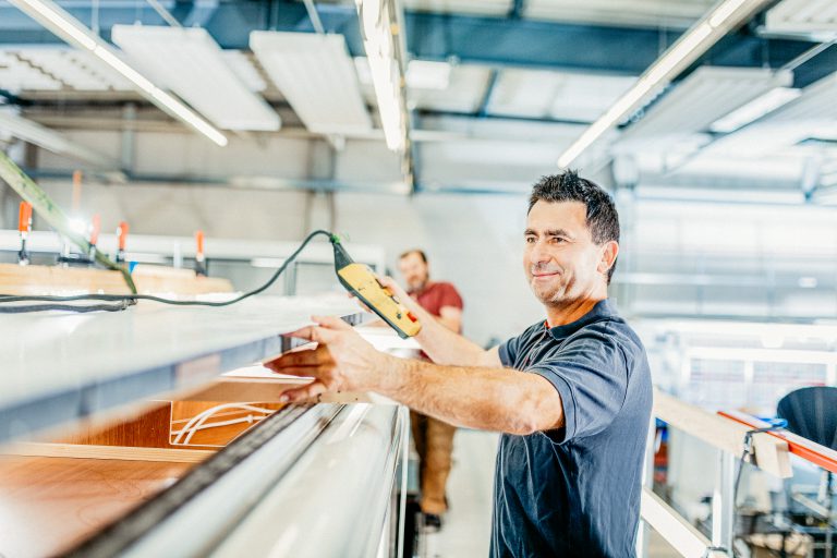 Techniker an einer Hebebühne in zum einbau der Truma Aventa Klimaanlage