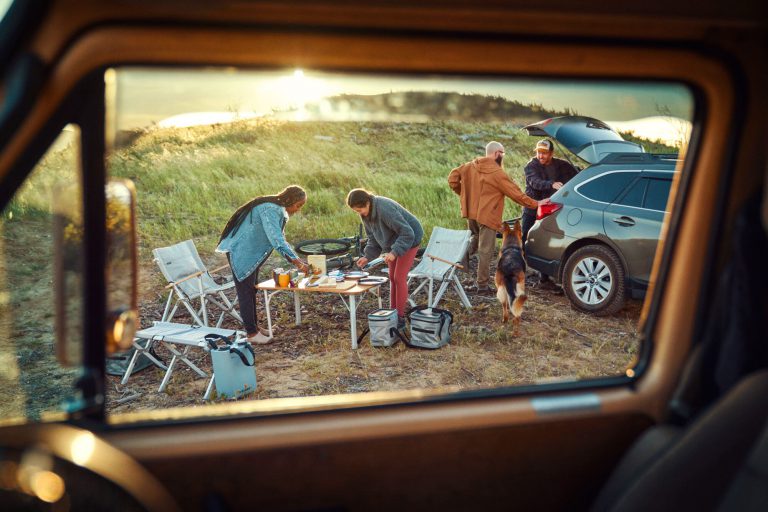 Blick aus Wohnmobil auf Familie beim Essen