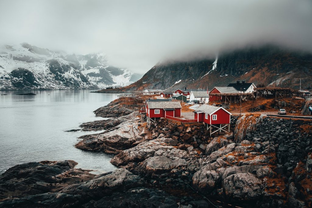 Eisnames Dorf in den Bergen an einem Fjord