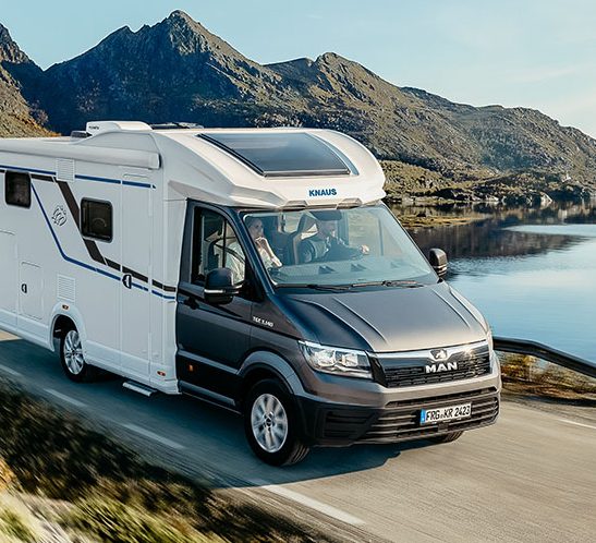 Teilintegriertes Wohnmobil auf Straße in Berglandschaft