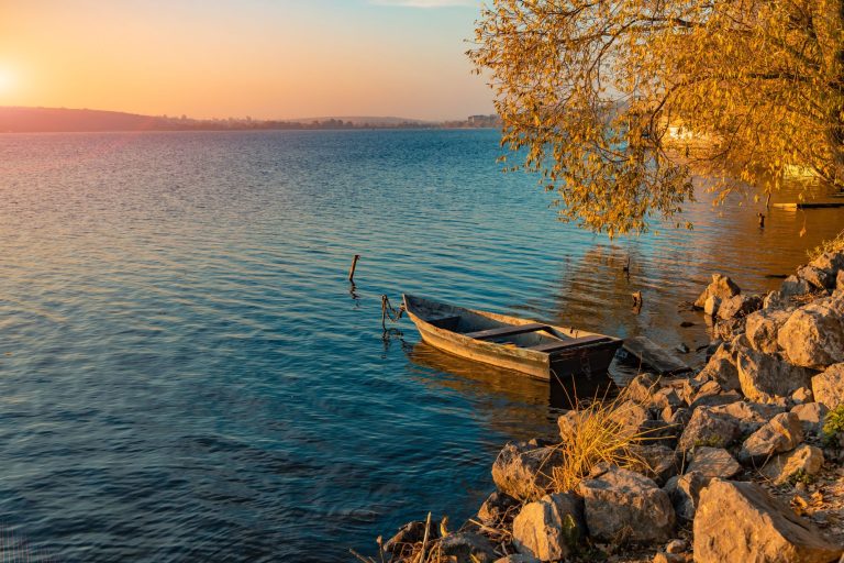 See mit Boot am Ufer bei Sonnenuntergang