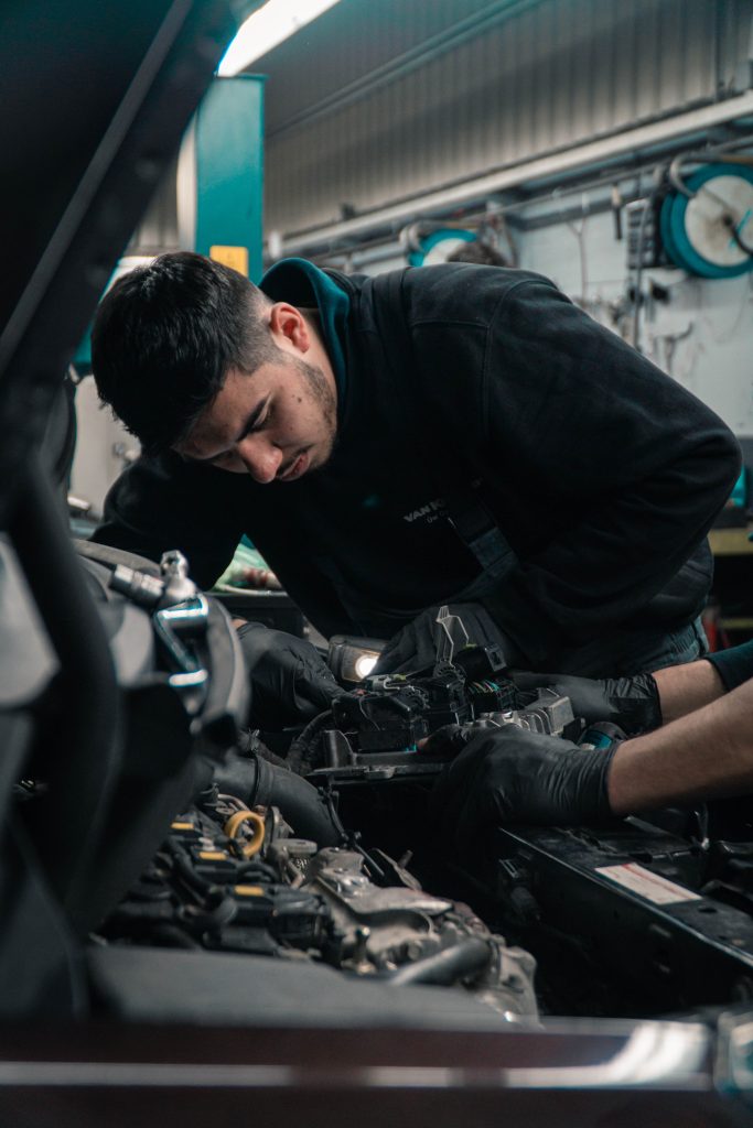 Mechaniker an offener Motorhaube 