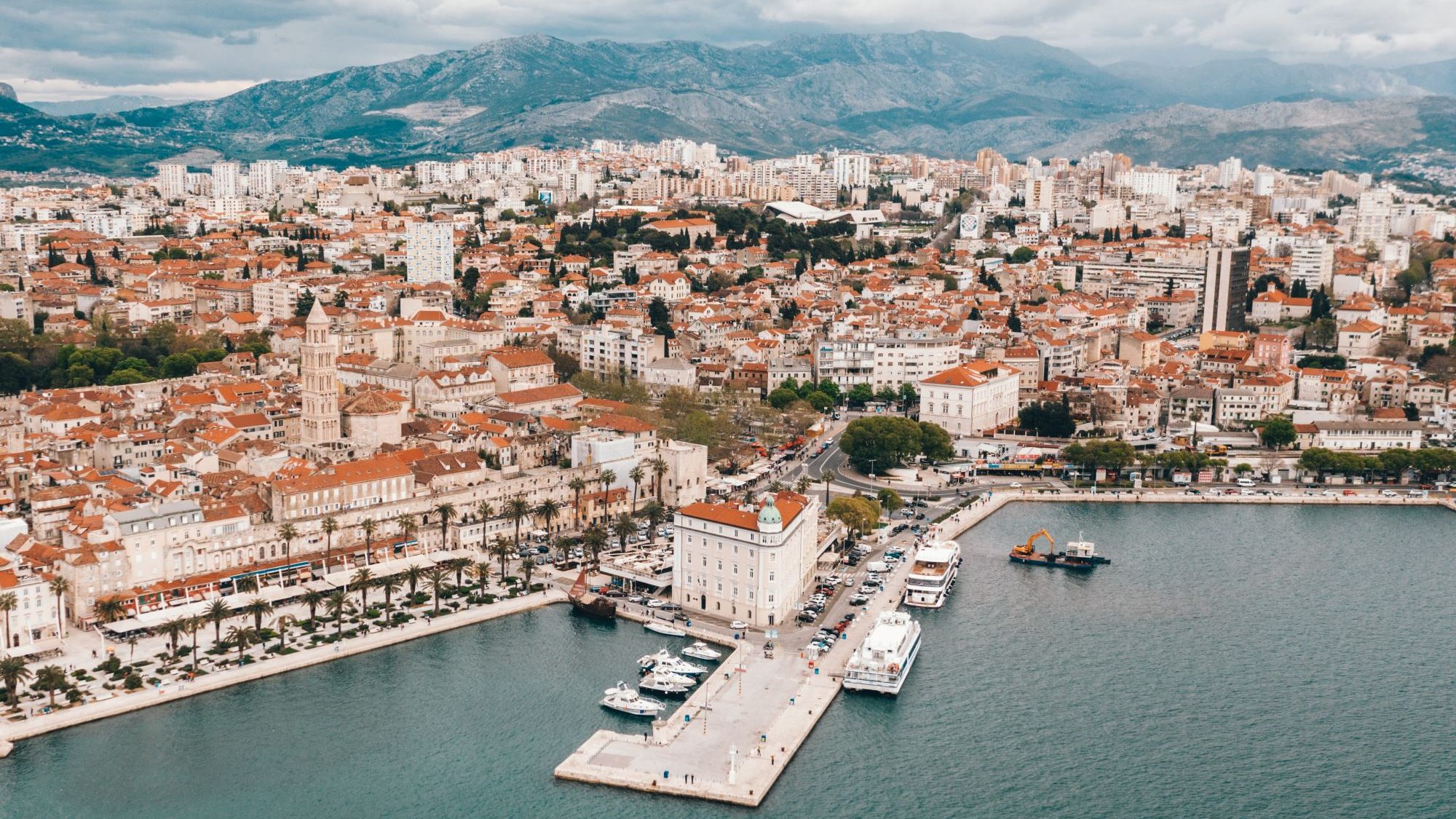 Blick auf die Stadt Split mit weißen Häusern und roten Dächern. Im Hintergrund  sieht man Berge