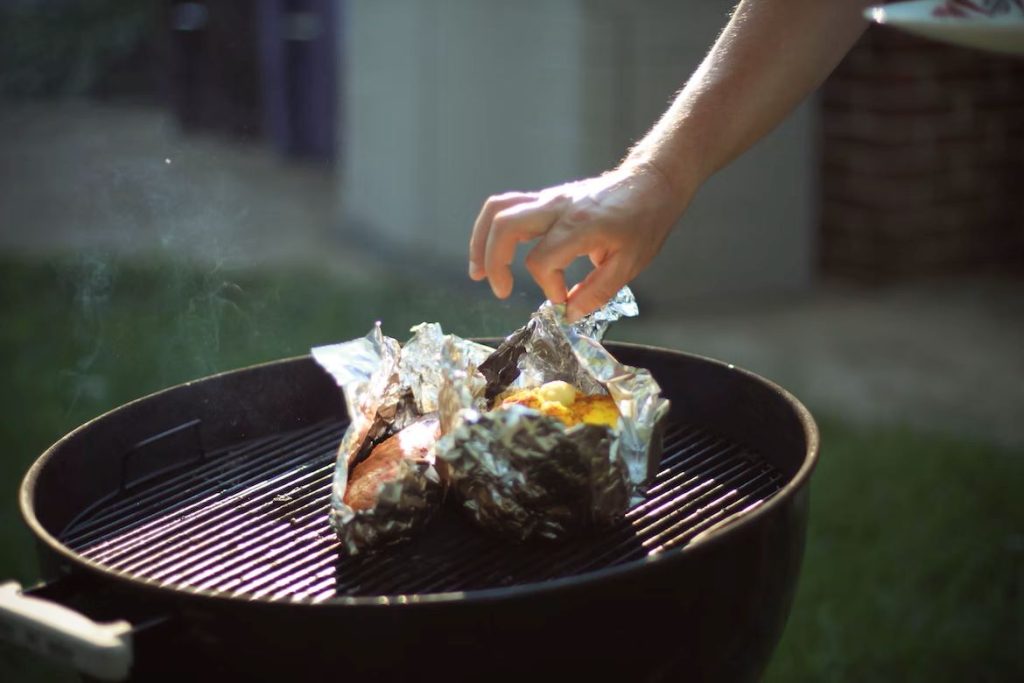 Camping-Rezepte Vegetarisch - Blick auf Süßkartoffel-Feta-Päckchen auf einem Grill.