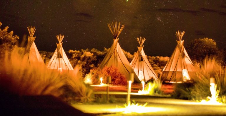 Glamping Italien - Blick auf verschiedene Zelte bei Nacht.