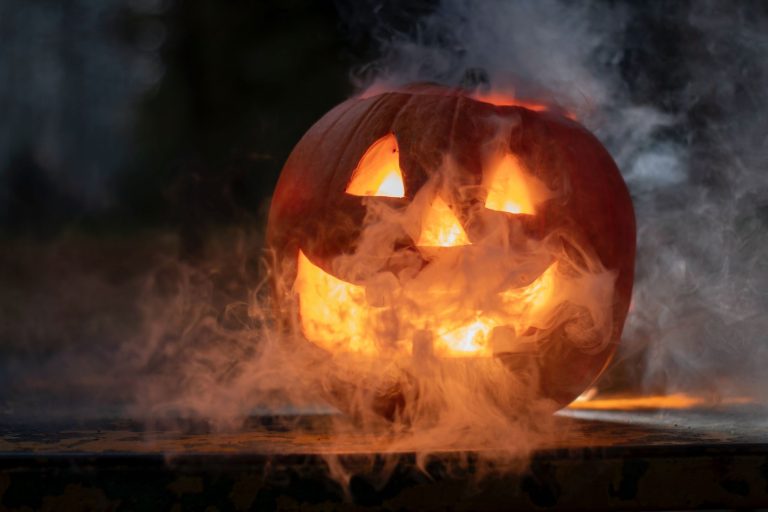 Halloween Wochenende - Blick auf einen geschnitzten leuchtenden Kürbis.