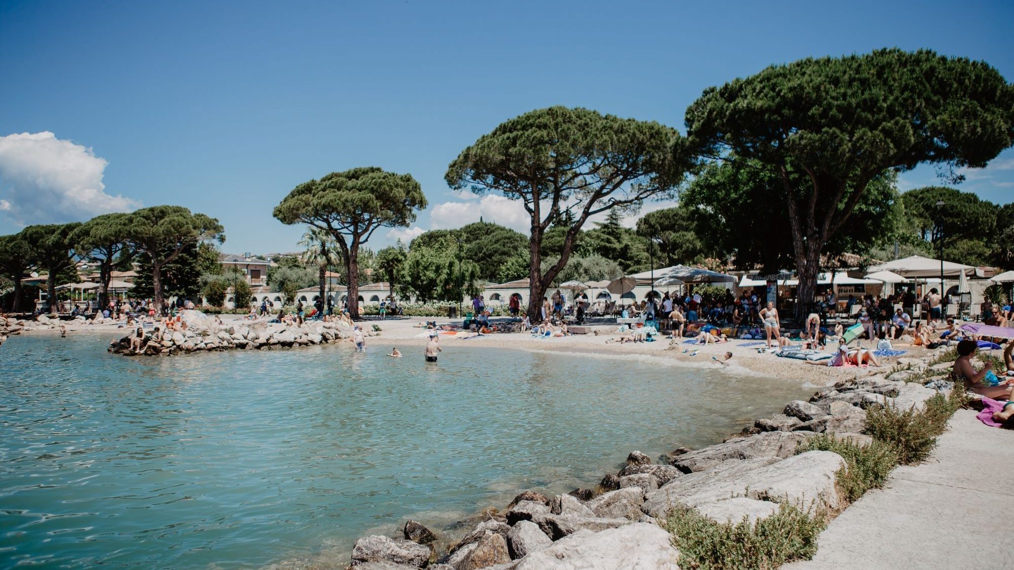 5 Sterne Camping Gardasee - Strand in Lazise mit Bäumen und Steinen