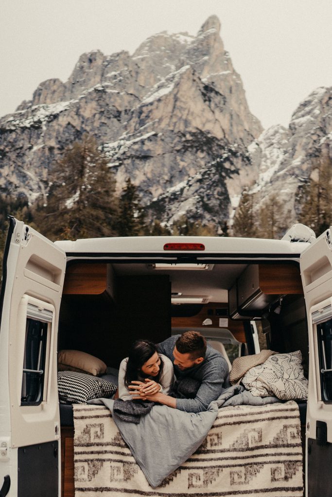 Campingplatz nur für Erwachsene - Pärchen liegt im Heck eines Wohnmobils und lacht