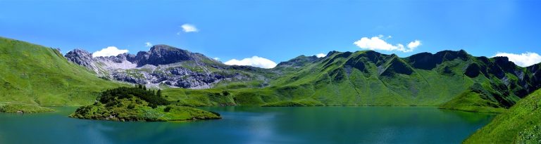 Glamping Allgäu - Blick auf die Landschaft mit Bergen und einem See im Allgäu.