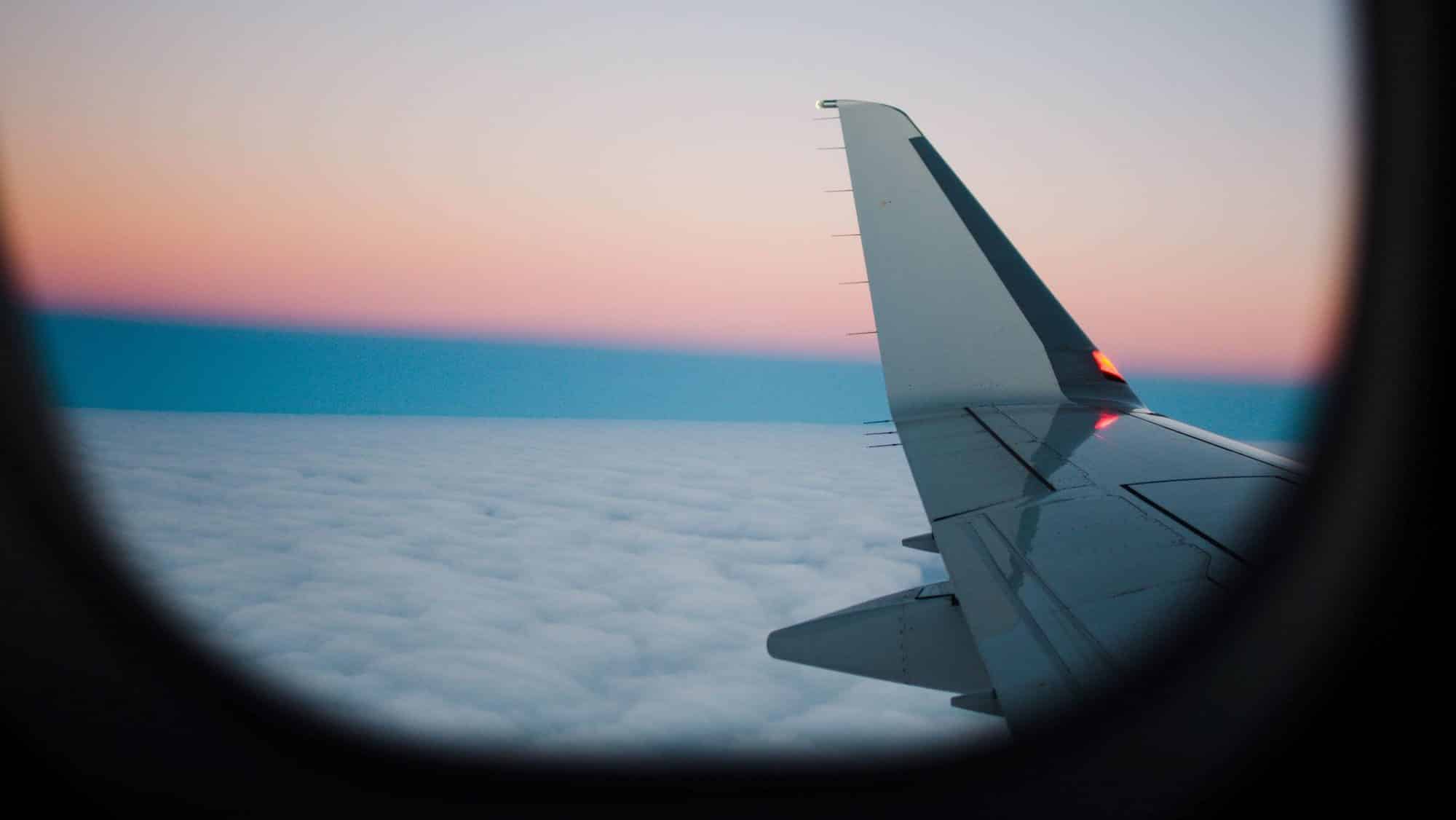 Campingurlaub mit dem Wohnmobil - Blick aus einem Flugzeug auf Wolken