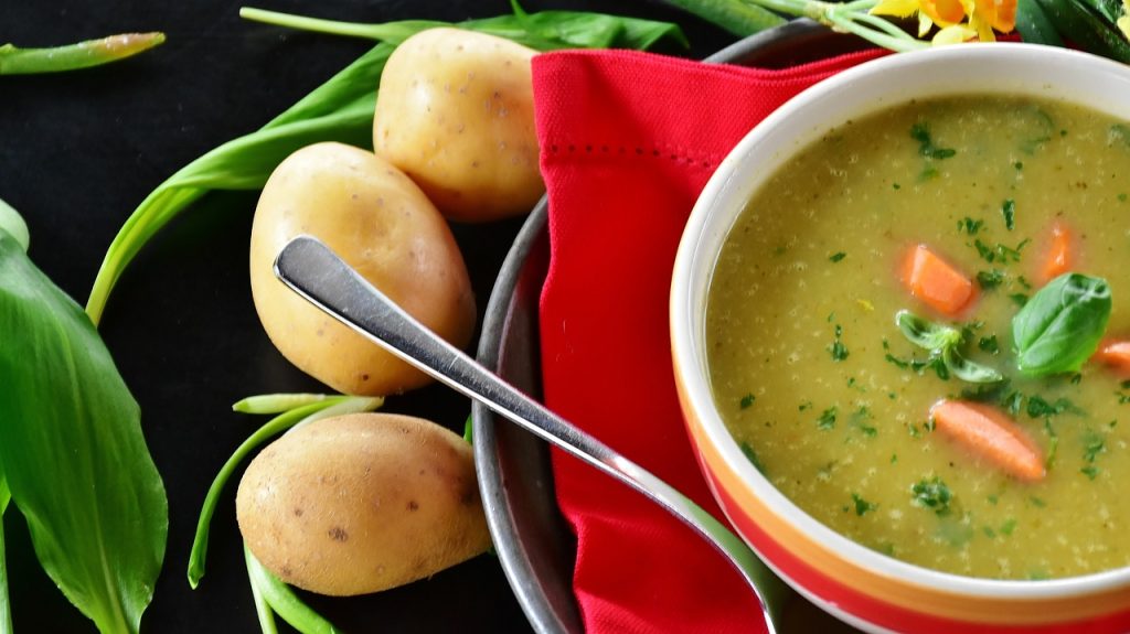 Winter Rezepte - Blick auf eine Kartoffelsuppe mit Kartoffeln im Hintergrund.