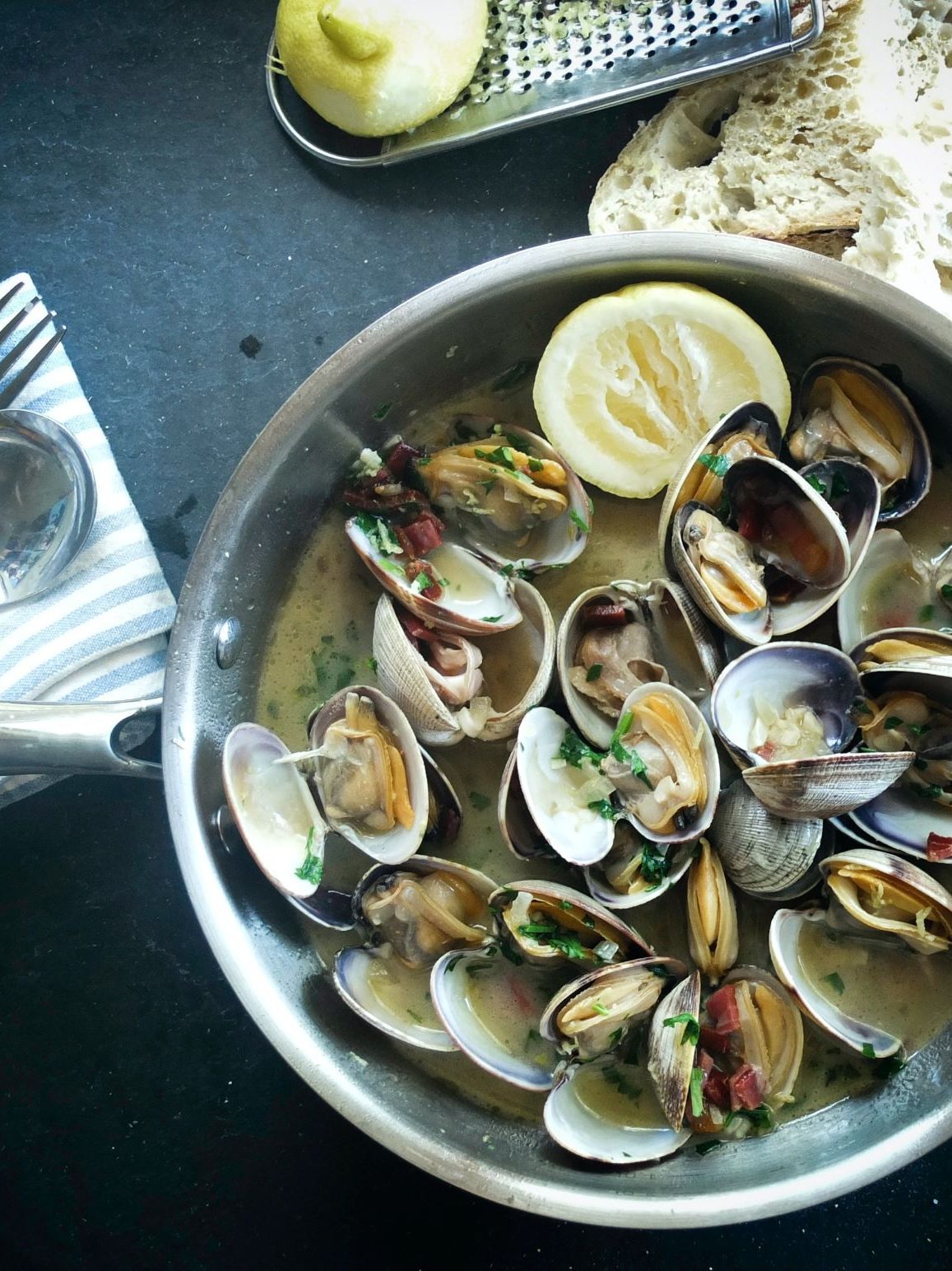 Muscheln in einem Kochtopf mit Zitrone und Kräutern