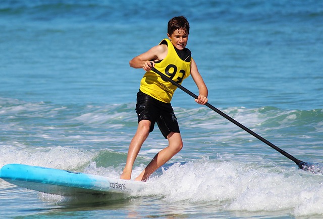 Camping Costa Brava - Blick auf einen Jungen beim Stand-Up-Paddling.