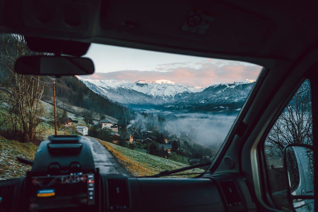 Brückentage 2024 NRW - Blick aus dem Fenster eines fahrenden Wohnmobils mit Bergen im Hintergrund.