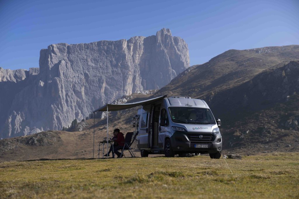 Wildcampen Strafen - Blick auf ein abgestelltes Wohnmobil mit ausgefahrener Markise in der Natur.